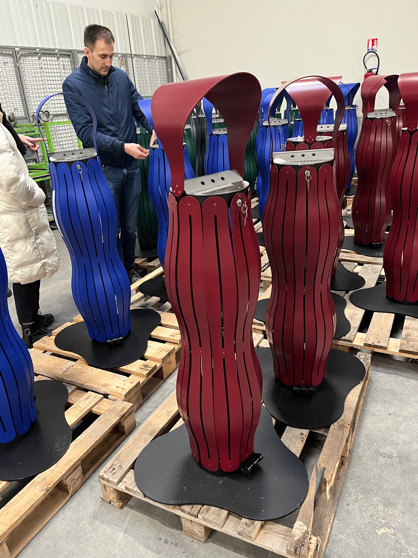 Un compagnon de l&rsquo;atelier passe en revue les cendriers termin&eacute;s, un rouge vigne au premier plan