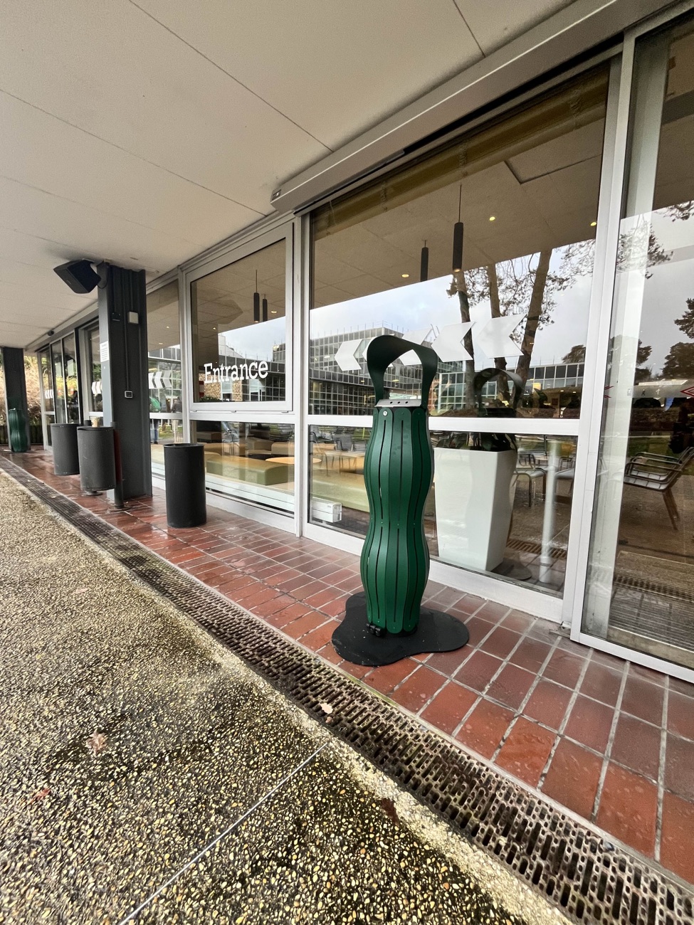 Cendrier install&eacute; sur un campus universitaire, &agrave; l&rsquo;entr&eacute;e d&rsquo;un b&acirc;timent d&rsquo;enseignement