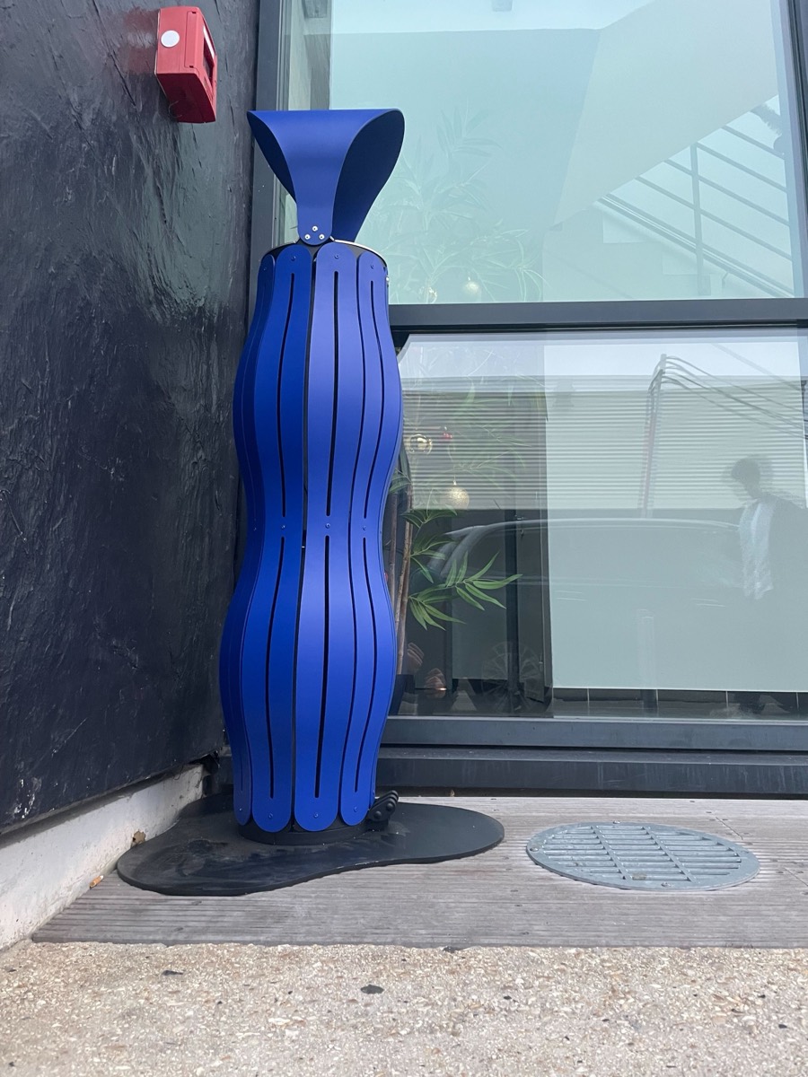 Cendrier bleu ultramarine devant un b&acirc;timent industriel en bardage