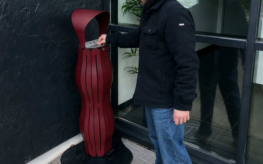 Cendrier rouge vigne install&eacute; devant un b&acirc;timent public