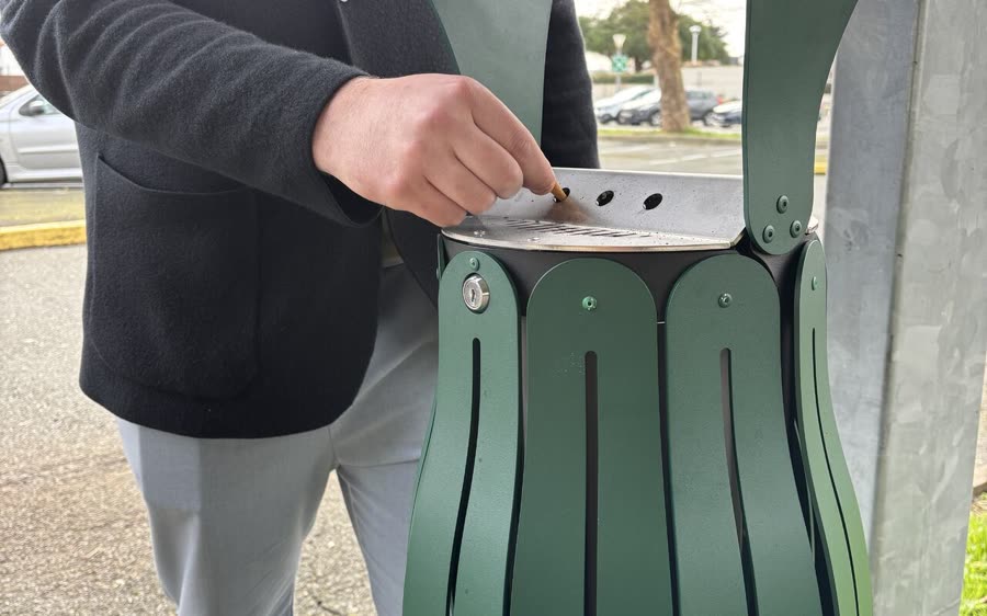 Une main d&eacute;pose une cigarette dans le cendrier